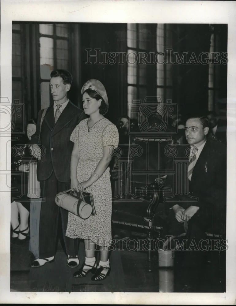 1939 Press Photo Paris couple , gas masks in hand, listening to Mayor