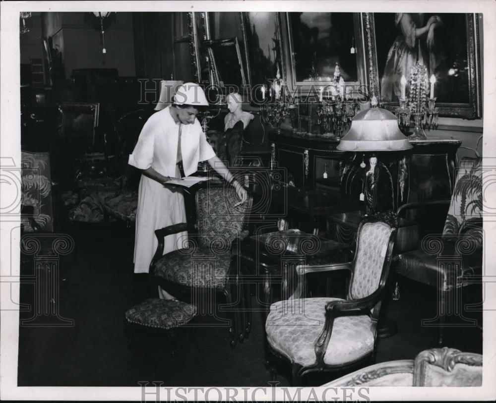 1953 Press Photo A woman bargain hunting furniture at a auction
