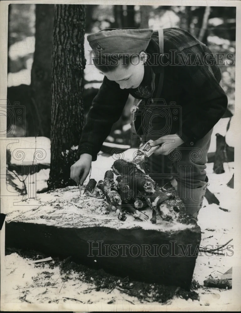 1959 Press Photo of James Carleton building a fire on a rock.