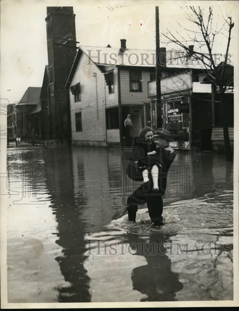 1937 Press Photo Flooded Town, Woman Being Carried Out of Water By Man