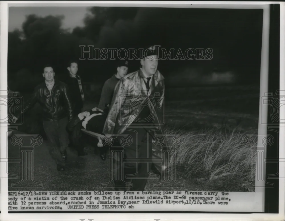 1955 Press Photo Rescuers carry a victim's body out of the crashed Italian plane