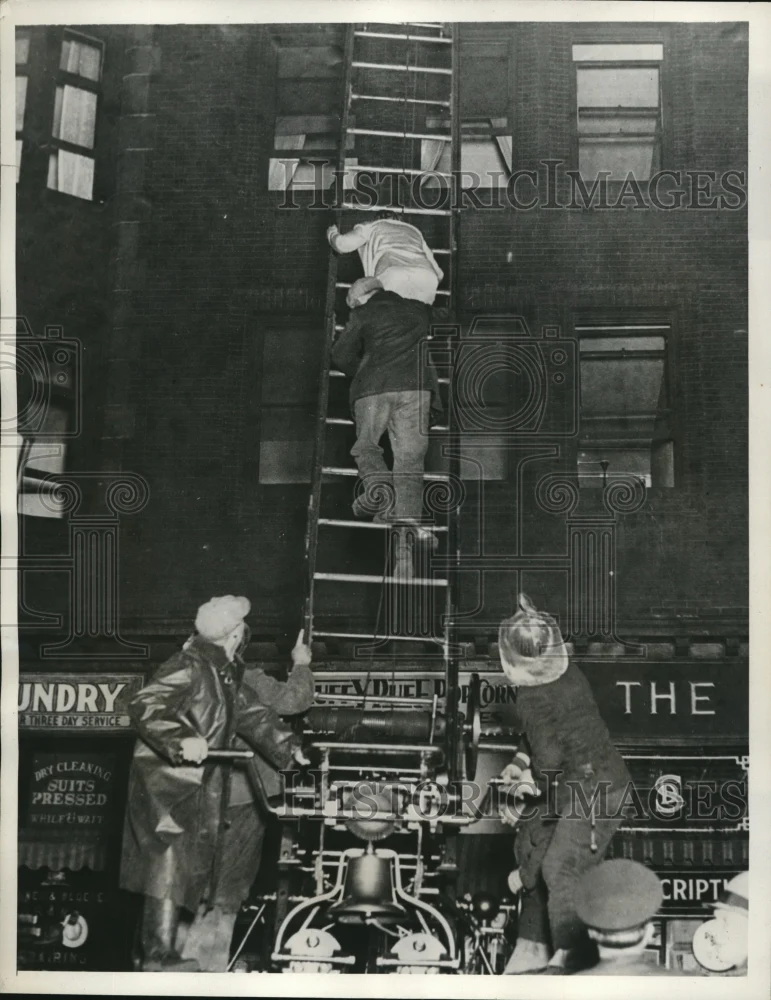 1932 Press Photo Cleveland Ohio firemen rescue woman from buring apartment