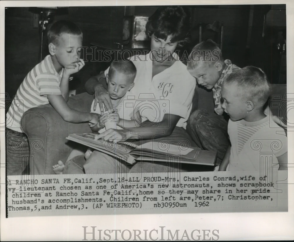 1962 Press Photo Astronaut Charles Conrad's family looking at his scrapbook
