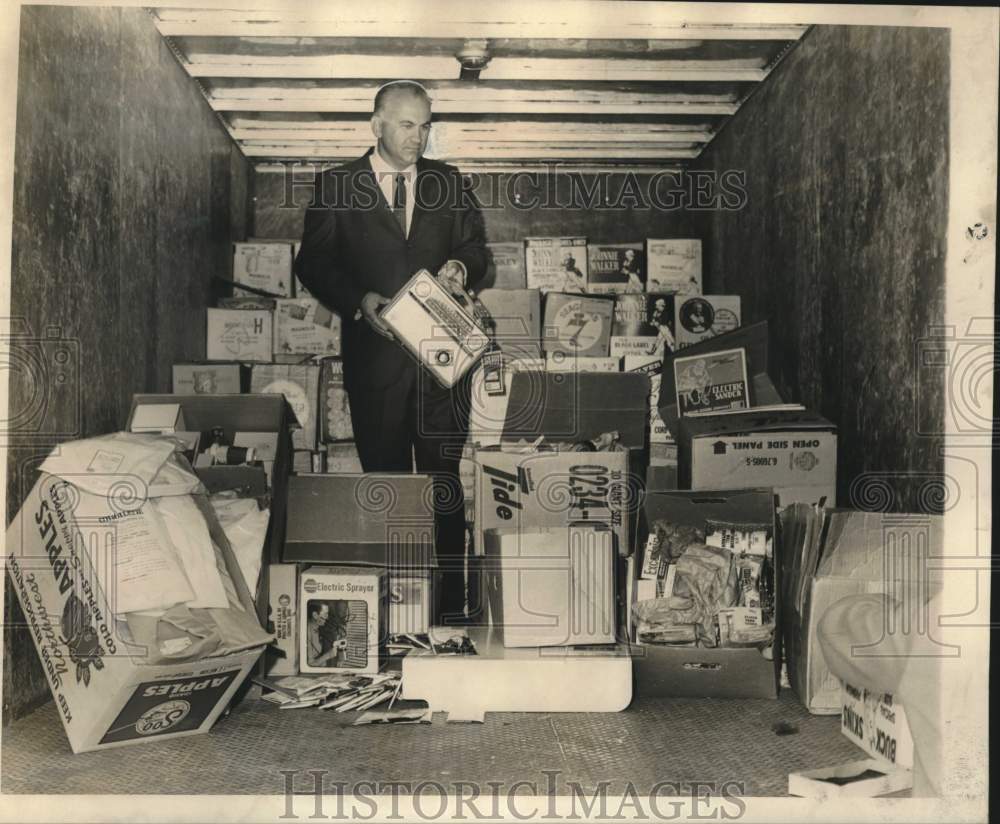 1967 Press Photo Private investigator Joseph A. Oster checks stolen merchandise