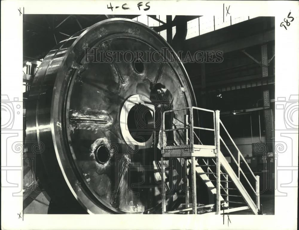 1975 Press Photo General Electric worker checks dimensions of 16-foot gear blank
