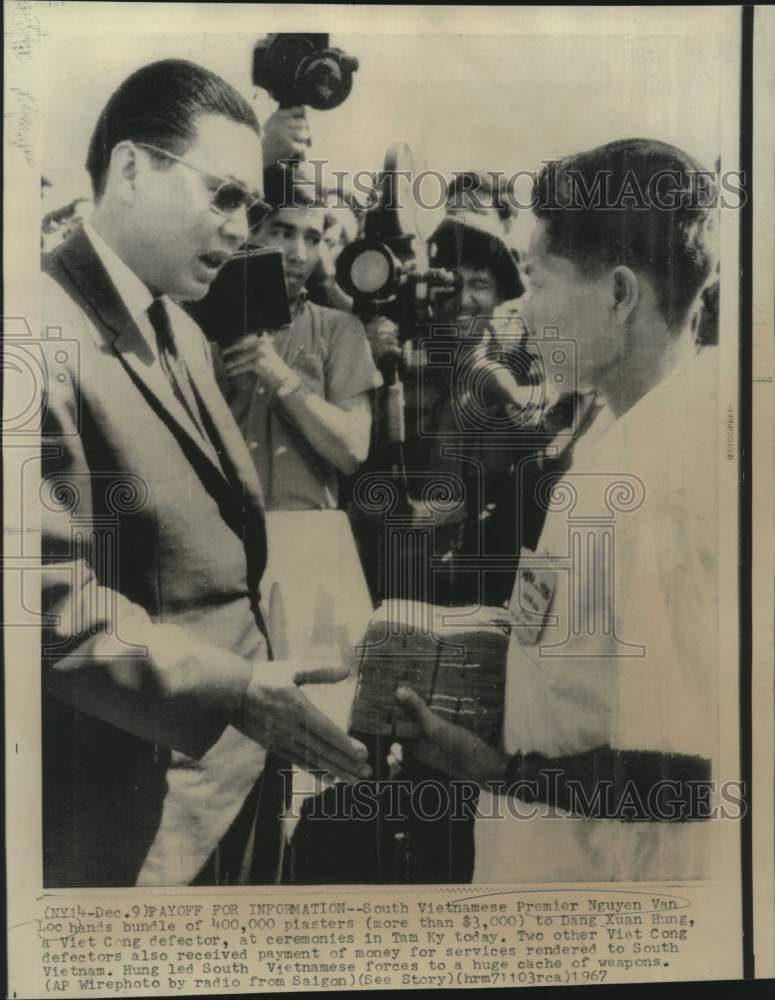 1967 Press Photo South Vietnam's Premier Nguyen Van Loc hands plasters to Hung